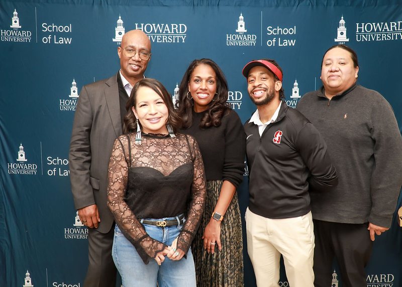 Five members of the Aequitai advisory board standing together in front of a Howard University School of Law backdrop.